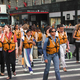 Life-jacketed pedestrians cross a busy intersection in Manhattan.